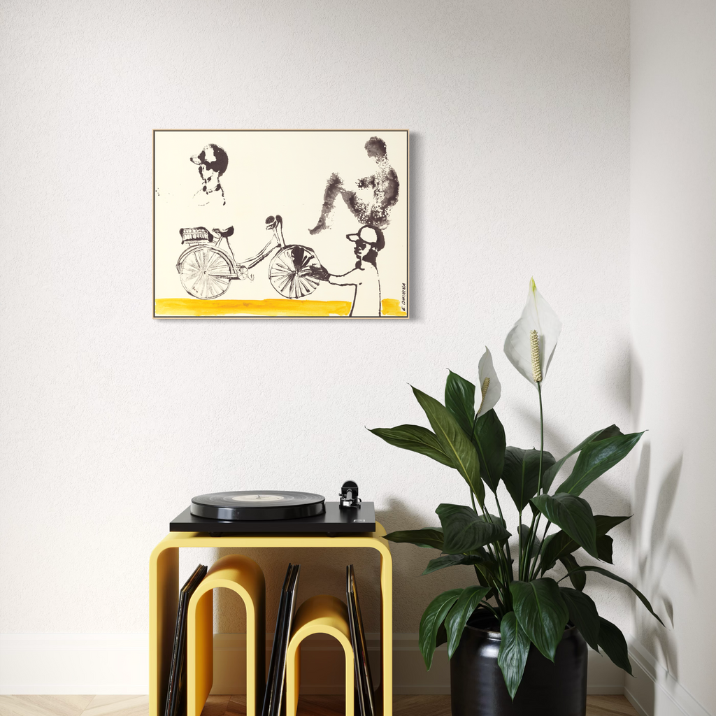 Yellow side table with black stools against a white wall with a framed Art Print depicting a bicycle on the wall.